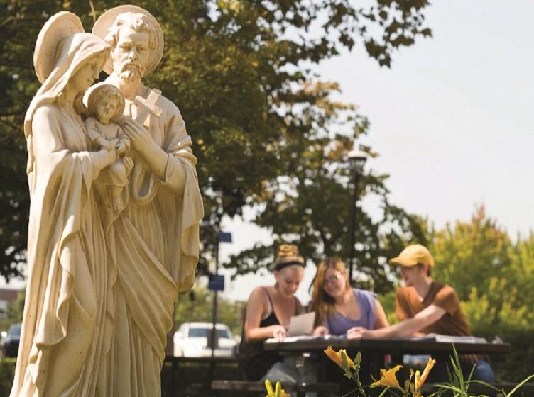 Statue of the Holy Family with students in the background